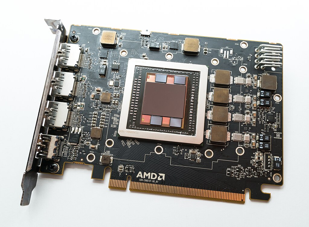 Close-up photograph of HBM memory stacks mounted on an AMD Fiji GPU package (Radeon R9 Nano), showing the four HBM cubes surrounding the central GPU die on a silicon interposer
